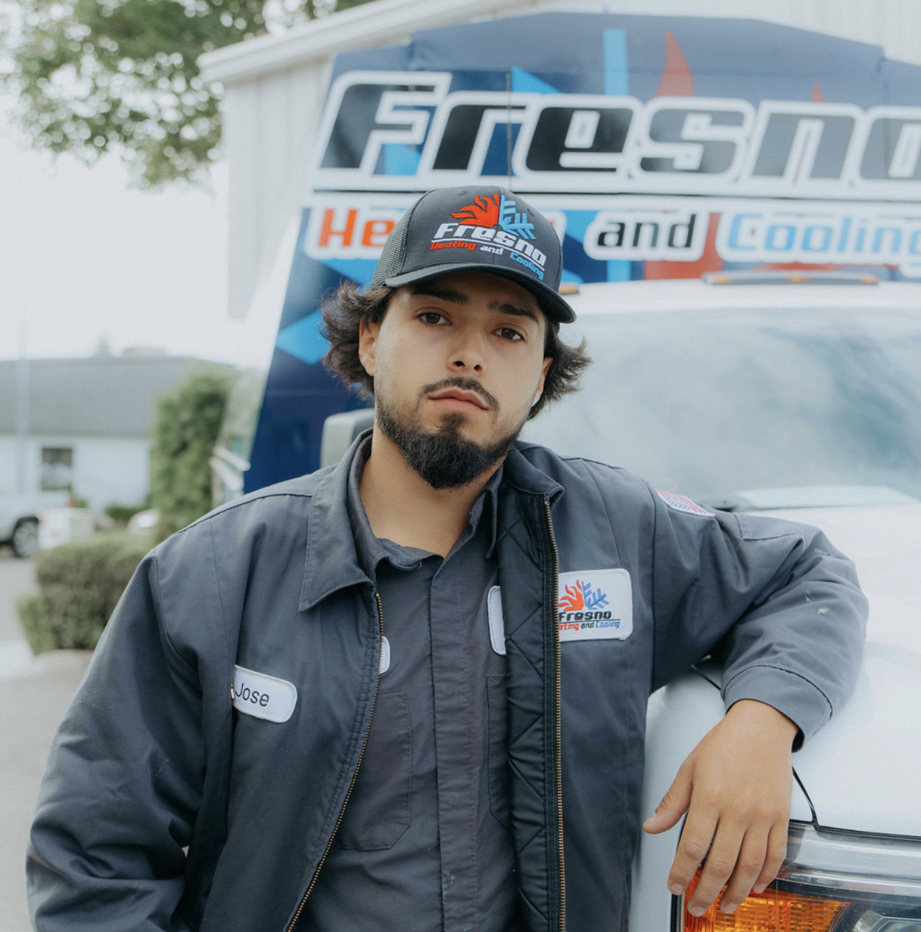 Jose M, service technician at Fresno Heating and Cooling, leaning against a company service truck