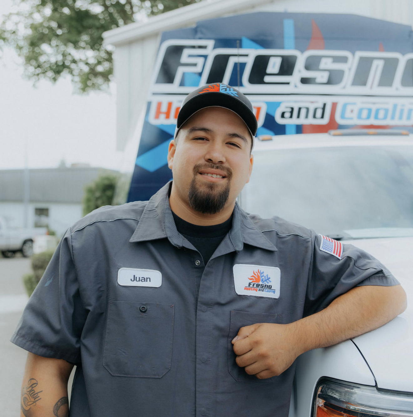Juan, install lead at Fresno Heating and Cooling, standing in front of a company service truck