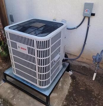Outdoor electric heat pump unit installed beside a home